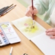 older woman paints a watercolor of a flower