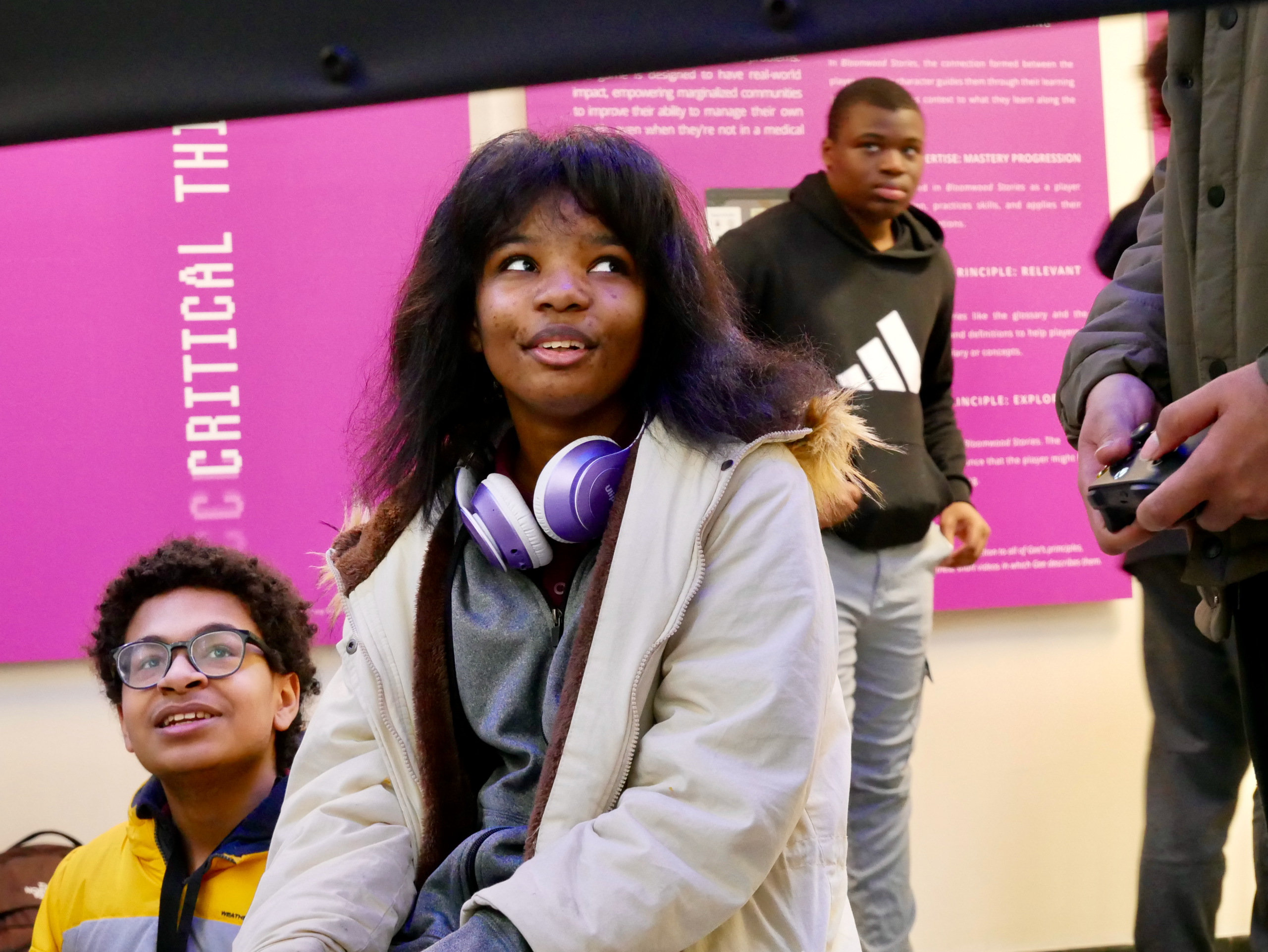 Tween girl and boy at video game station in the exhibition. 