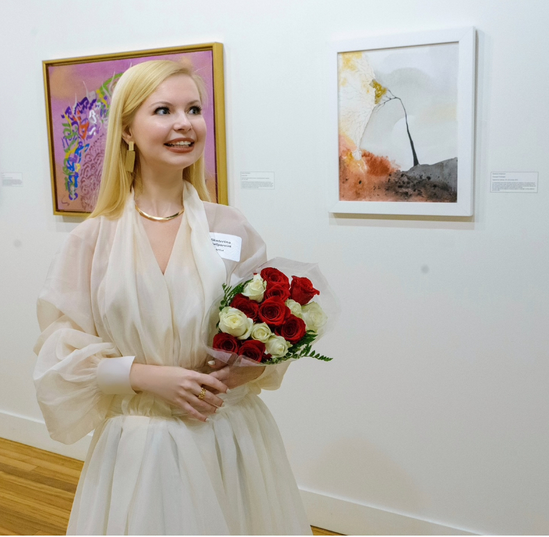 Ekaterina Stolyarova poses next to one of her paintings