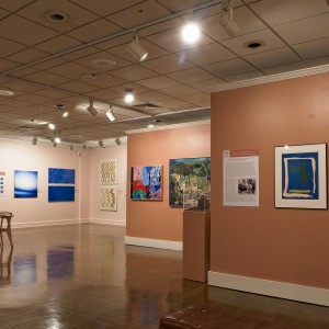 Installation photo of the Power of Two exhibition, with paintings mounted on the wall and other works on pedestals.